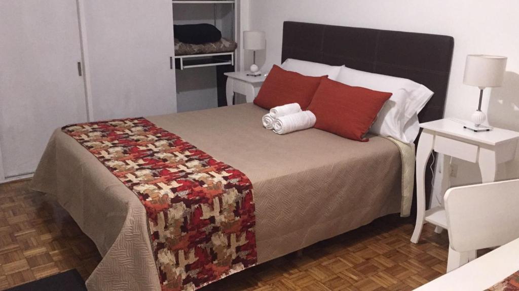 布宜诺斯艾利斯Palermo Botánico的一间卧室配有一张带红色枕头的大床