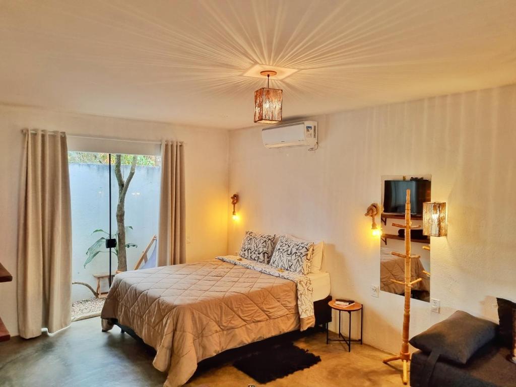 戈亚斯州上帕莱索Morada dos Saguis的一间卧室配有一张床、一张沙发和一个窗口