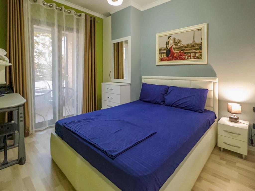 地拉那Downtown Grand Comfort的一间卧室设有蓝色的床和窗户。