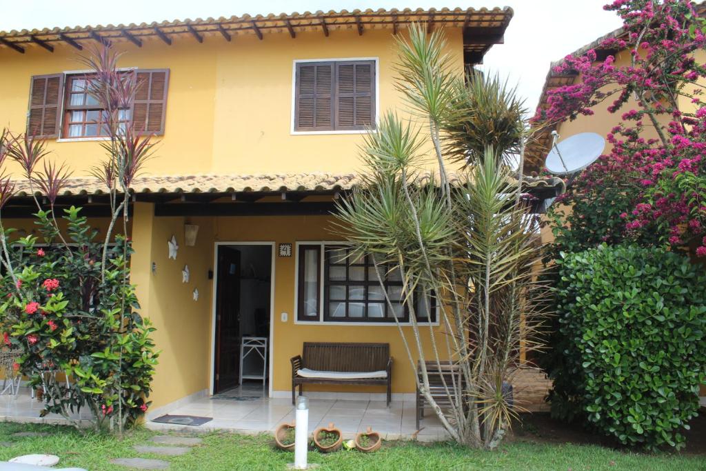布希奥斯Casa em Búzios com Vista para o Mar的院子里的黄色房子,带椅子
