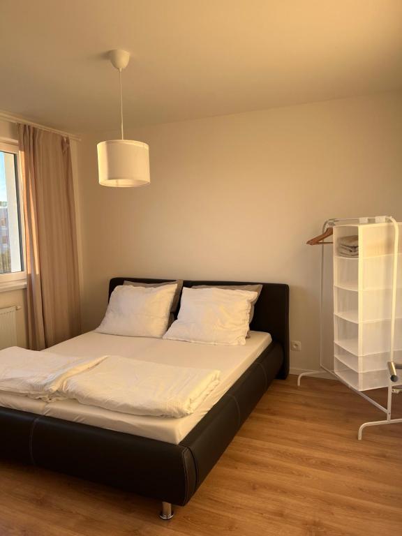 PrievozContemporary Airport Retreat的一间卧室配有一张带白色床单和架子的床