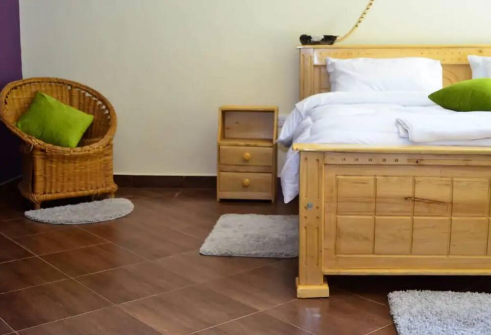 埃尔多雷特Zuri Guest House next to SOS & Kenmosa Village的一间卧室配有一张床、一把椅子和一个床头柜