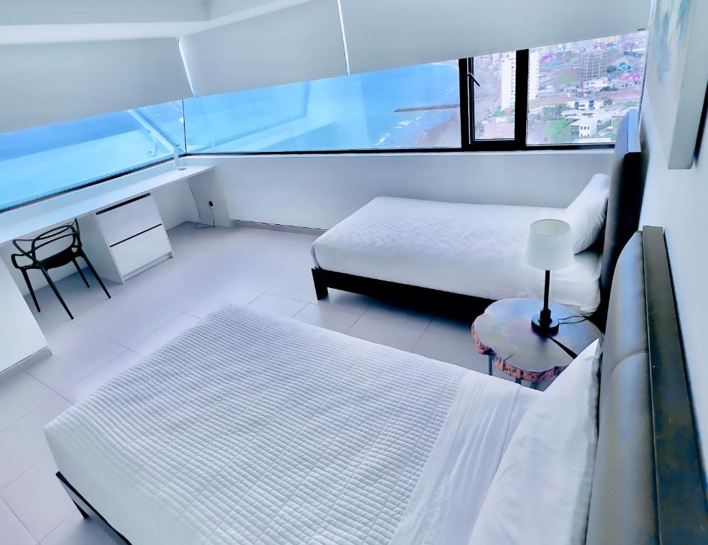 曼塔The Best Luxury Penthouse - Beach View的白色的客房设有床和窗户。