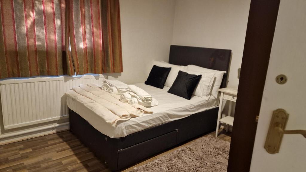 伦敦House的卧室内的一张带白色床单和枕头的床