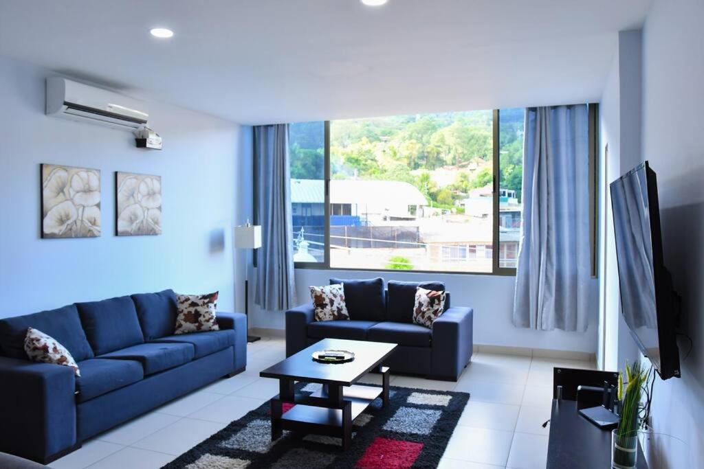 圣萨尔瓦多Los Cielos302: Spacious Condo with scenic views.的客厅配有蓝色的沙发和桌子
