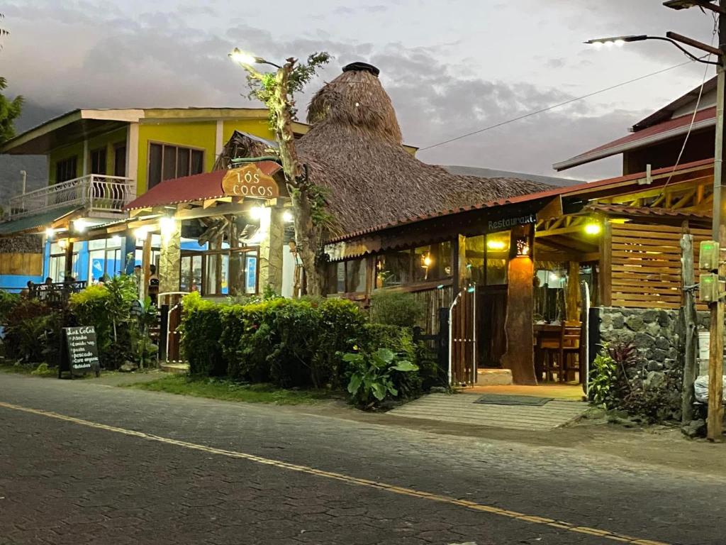 Santa CruzHotel Restaurante Los Cocos的街道上茅草屋顶的建筑