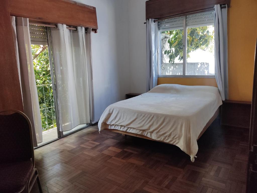 蒙得维的亚Patio Urbano Suites & beds的一间卧室设有一张床和两个窗户。