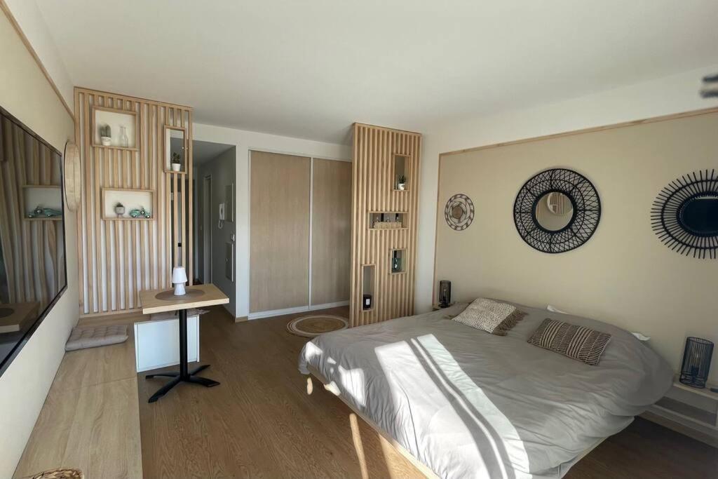 努美阿F1 standing vue mer Anse Vata的一间卧室配有一张床和一张桌子