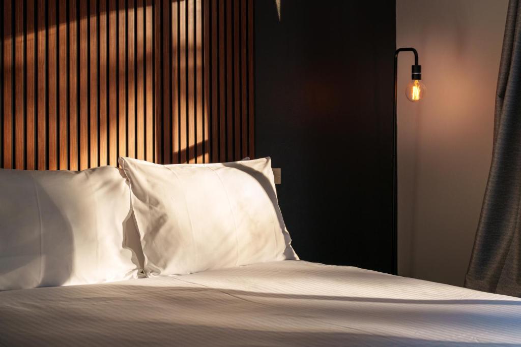 肯图巴Echo Point Discovery Motel的一张带白色床单和枕头的床