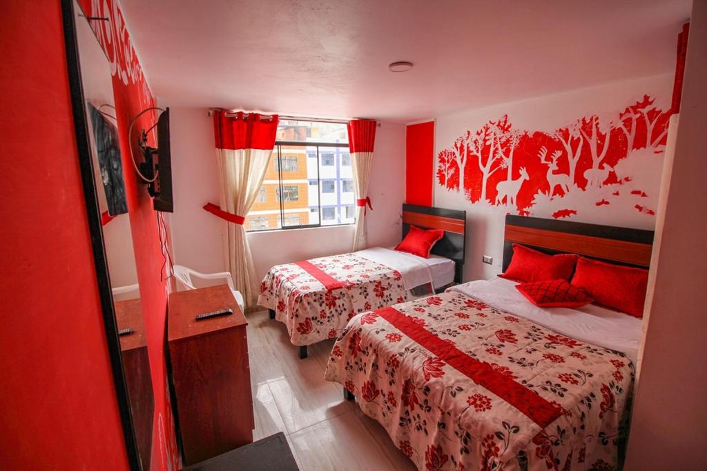 丘林Hotel D'Gloria的红色的客房设有两张床和窗户。