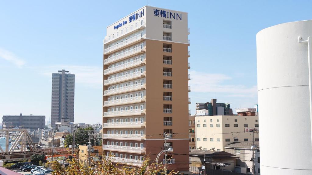 大阪Toyoko Inn Osaka Dome Mae的一座高大的建筑,上面有标志