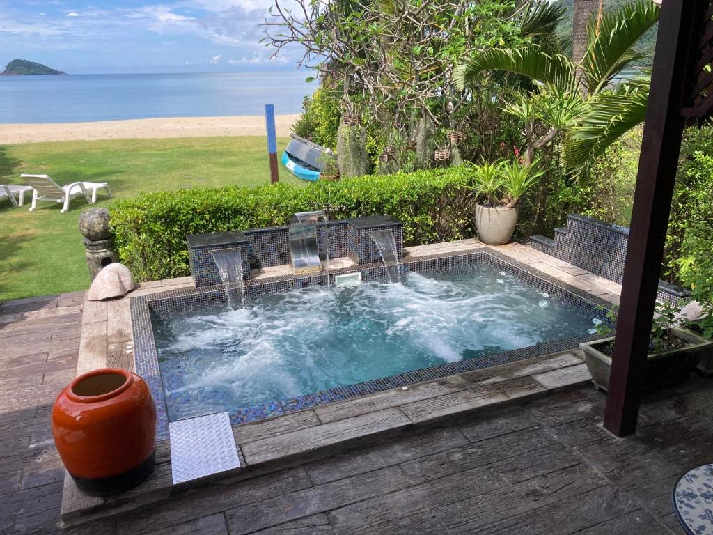 象岛暹罗帝景别墅酒店的一个带椅子的热水浴池和背景海洋