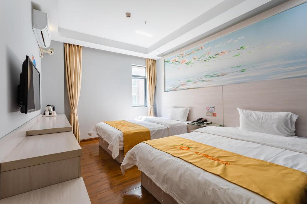 深圳七橙酒店(深圳北站民治店)的一间酒店客房,设有两张床和电视