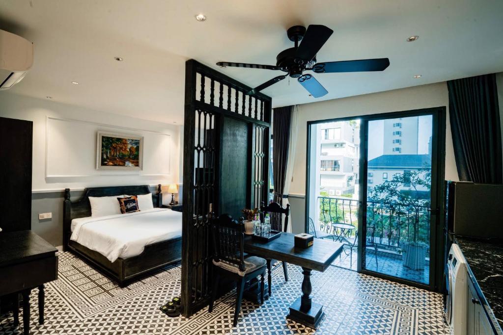岘港Dérive Boutique Villa & Apartment Da Nang的一间卧室配有一张床和吊扇