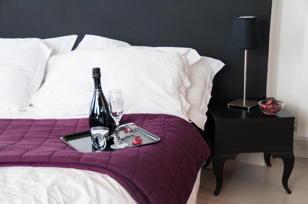 尼科洛西米开朗基罗别墅酒店的床上的托盘,包括一瓶葡萄酒和玻璃杯