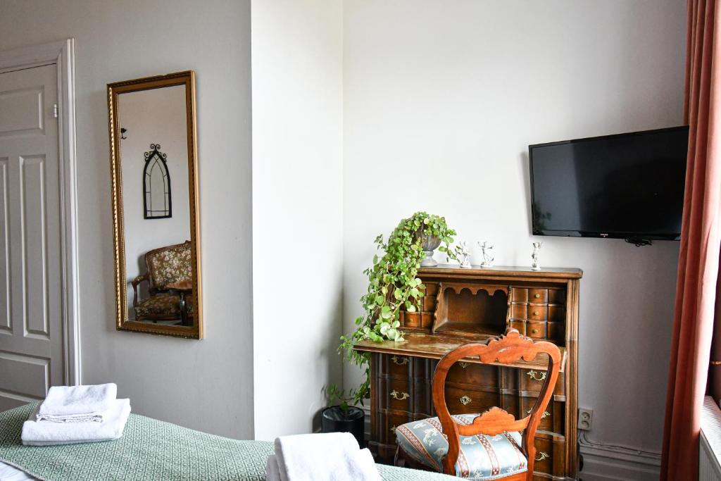 斯塔德普林斯卡尔酒店的配有电视、椅子和镜子的客房