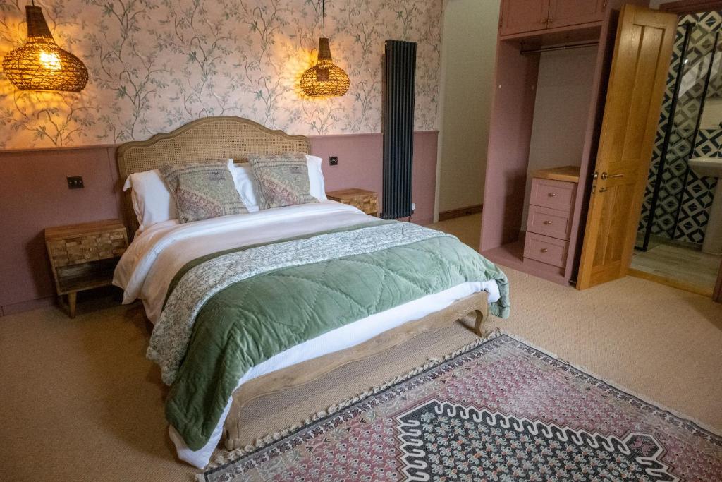韦尔斯The Sheep and Penguin的一间卧室配有一张带绿色棉被的床