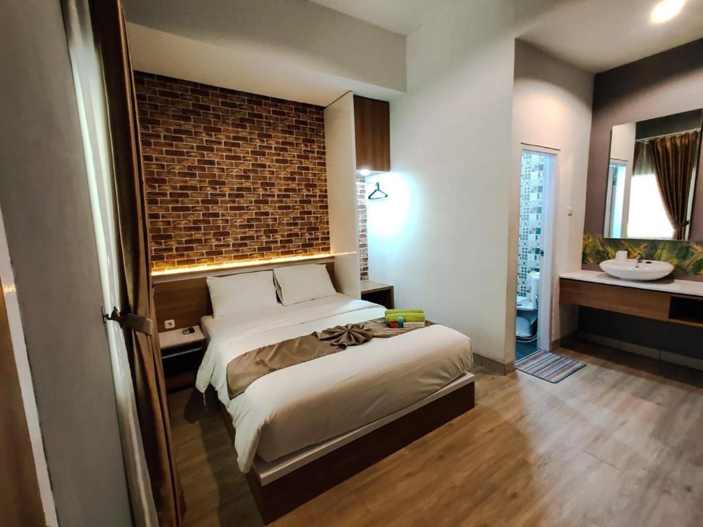 GondowulungCaniga Hotel Yogyakarta的一间卧室配有一张床,浴室设有水槽