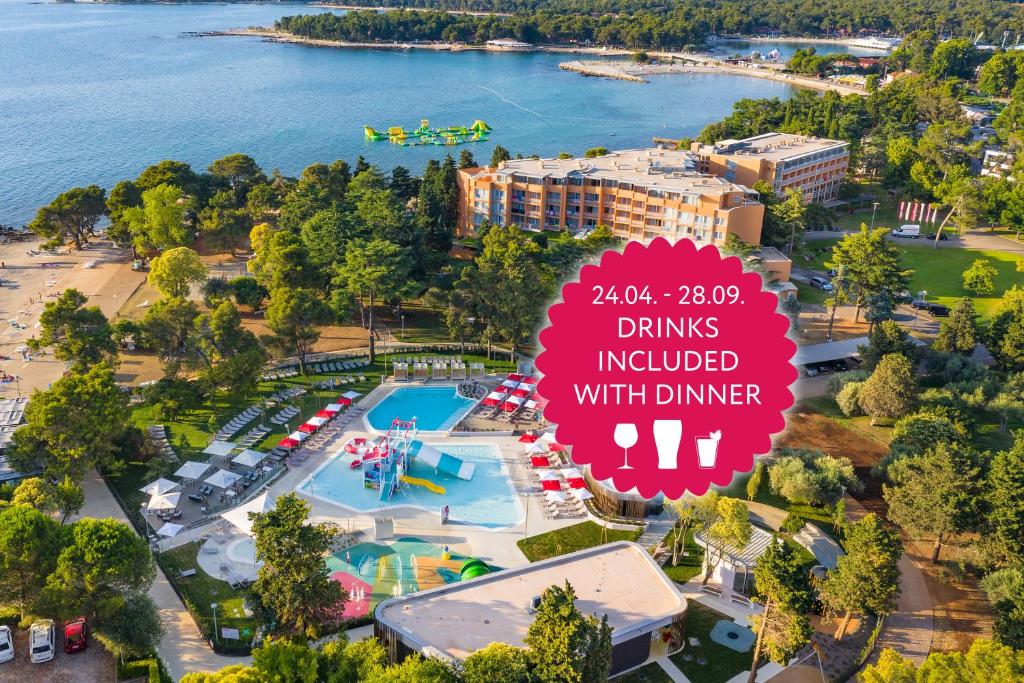 乌马格Hotel Umag Plava Laguna的享有水上公园的上方景色,设有阅读晚餐饮品的标志