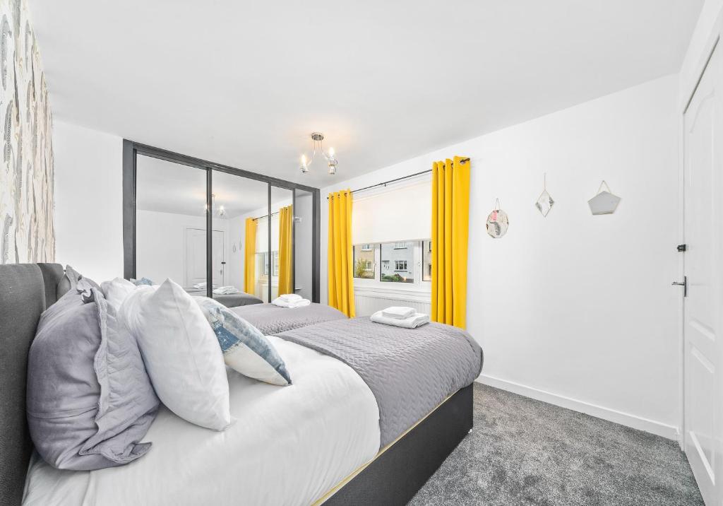 科特布里奇Rothesay House by Klass Living Coatbridge的卧室内的两张床,配有黄色窗帘