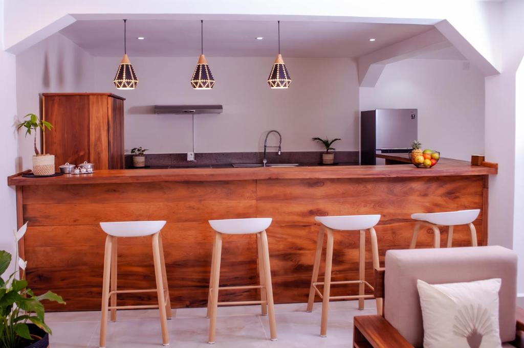 塔那那利佛Ampifitia Guest House的厨房设有带凳子的木制酒吧
