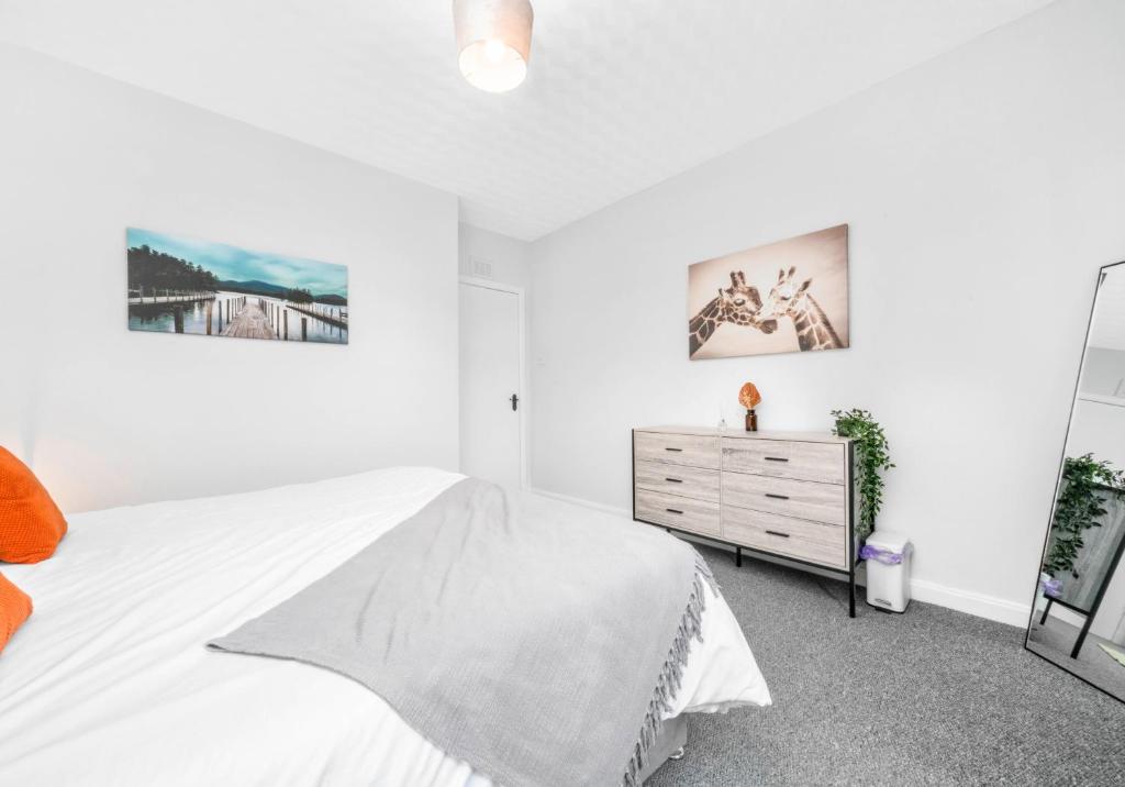 阿丁斯顿McCulloch Apartment by Klass Living Uddingston的一间白色卧室,配有一张床和一个梳妆台