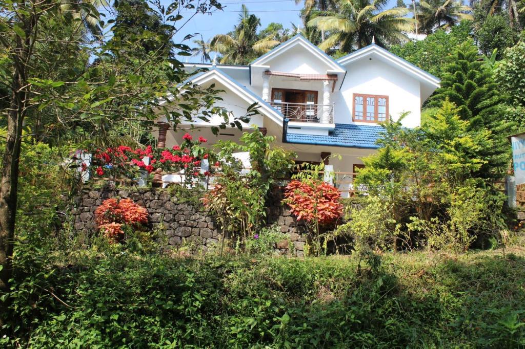 蒙纳Munnar Village Homes的前面有鲜花的房子
