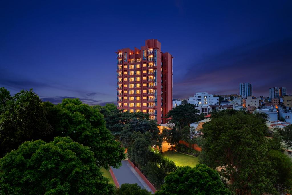 班加罗尔Lemon Tree Suites, Whitefield, Bengaluru的一座高大的建筑在晚上点燃