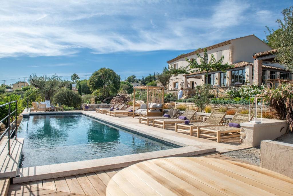 马赛LA BASTIDE DES CULS-ROUSSET的一个带椅子的游泳池以及一座房子