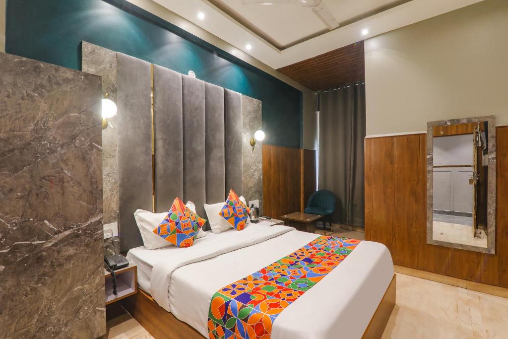FaizābādFabHotel Royal Palm Inn的一间卧室配有一张带色彩缤纷枕头的大床