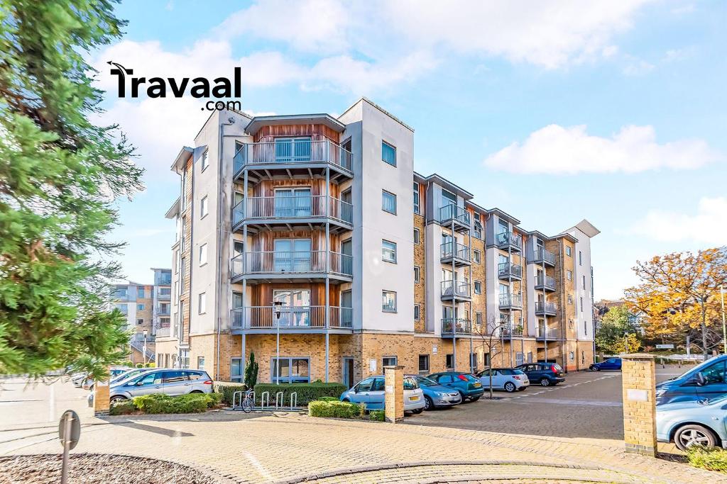 法恩伯勒Travaal.©om - 2 Bed Serviced Apartment Farnborough的停车场内有车辆停放的公寓大楼