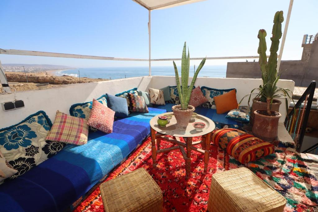 塔哈佐特Welle Surf Morocco的阳台配有带枕头的沙发和桌子。