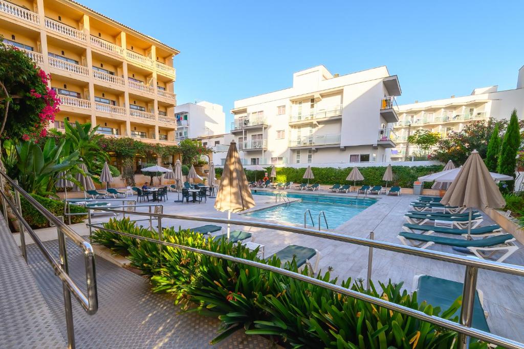 坎帕斯蒂利亚太阳岛公寓酒店的一个带游泳池、椅子和遮阳伞的度假村