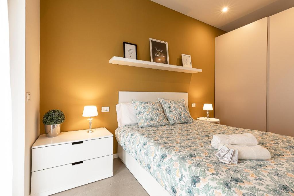 诺瓦拉[CentroNovara]Free Netflix-Wi-Fi的一间卧室配有一张床、两个床头柜和两盏灯。