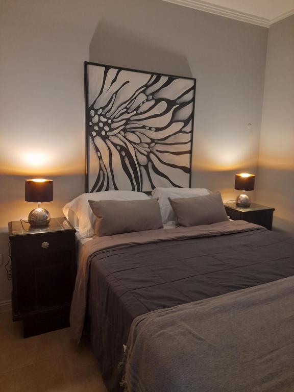 圣达菲Malala departamento en Santa Fe - ALOJAMIENTO DE CALIDAD的一间卧室配有一张大床,桌子上放着两盏灯