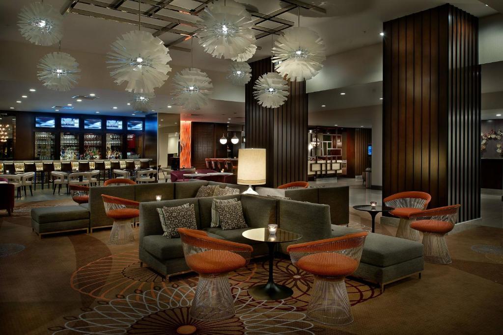 埃德蒙逊马里奥特酒店圣路易斯机场店的酒店大堂设有桌椅和吊灯。