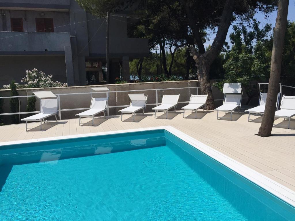 塔兰托拉维拉德拉梅达酒店的一组椅子和一个游泳池