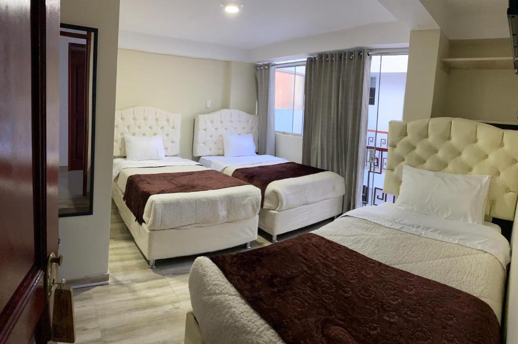 库斯科ANDEAN VALLEY HOTEL的酒店客房设有两张床和一个阳台。
