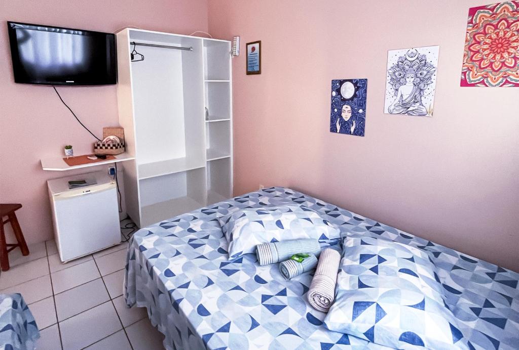 瓜尔达恩巴Pousada Águas do Embaú的一间卧室配有一张带蓝色和白色枕头的床