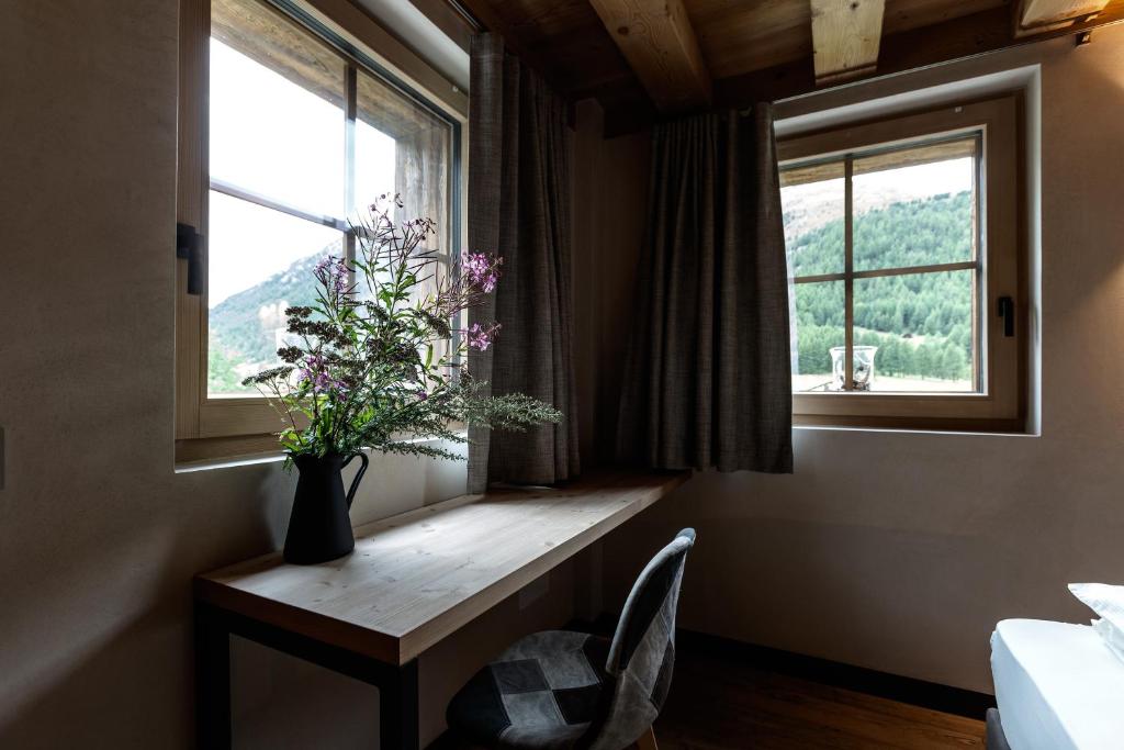 利维尼奥Snow Villa Genf with Spa的花瓶坐在窗台上的花瓶