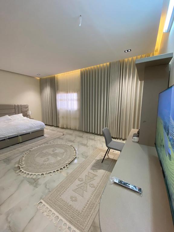 欧拉مشار العلا للشقق الفندقيه 1的一间卧室配有一张床和一张书桌及电视