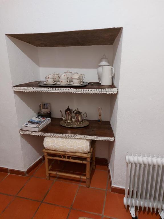 维拉维索萨A Casinha da Vila的小房间,配有带茶具的架子