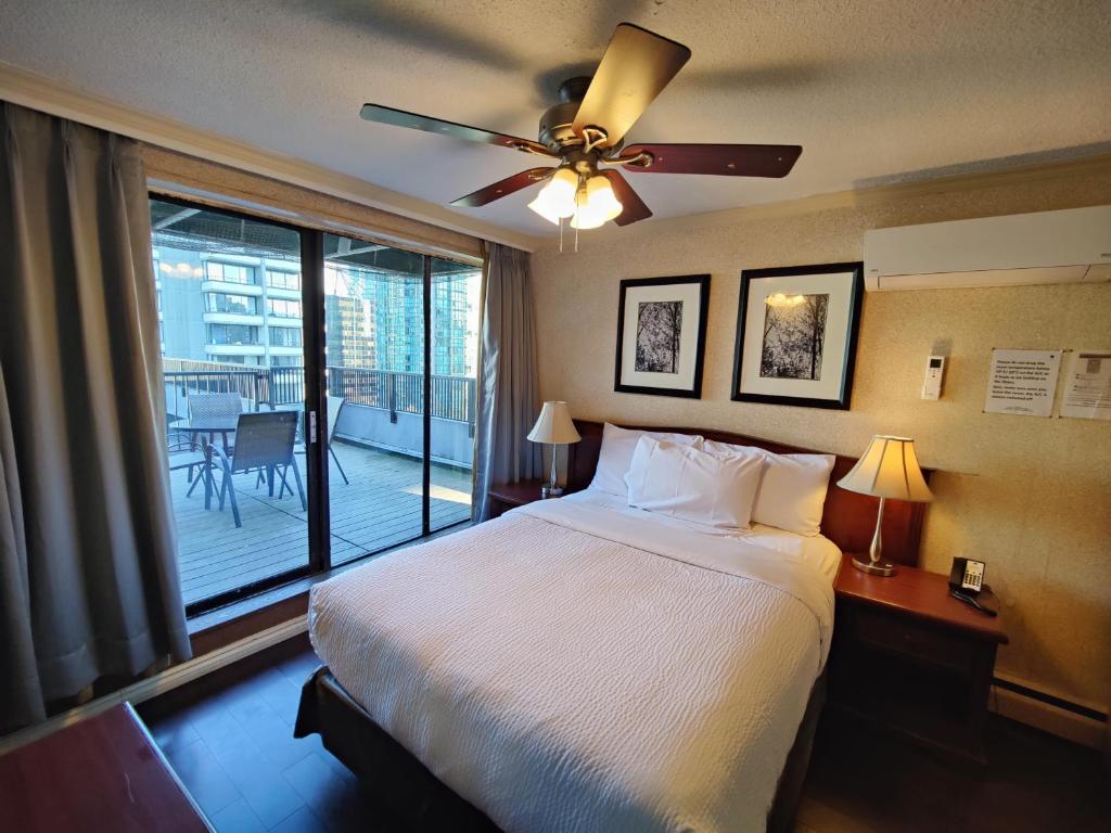 温哥华Divya Sutra Suites on Robson Downtown Vancouver的一间卧室配有一张床和吊扇