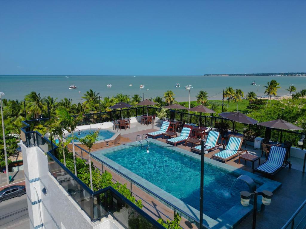 若昂佩索阿阿特克皮亚酒店的享有度假村游泳池和海洋的空中景致