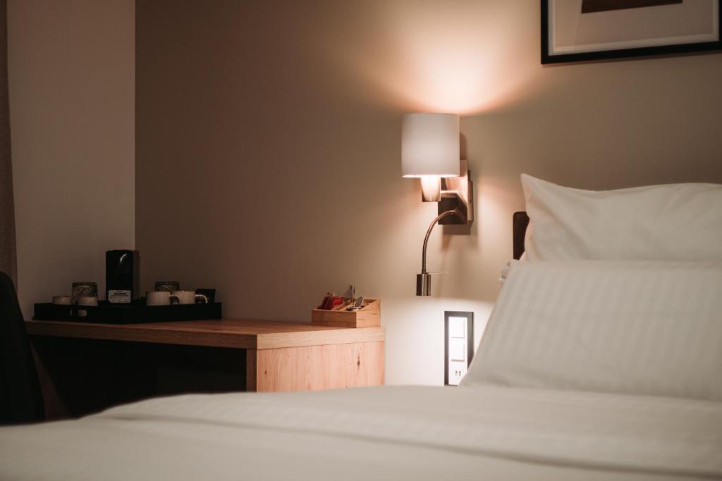德莱蒙Hôtel du Midi的一间卧室配有一张床和一张带台灯的书桌