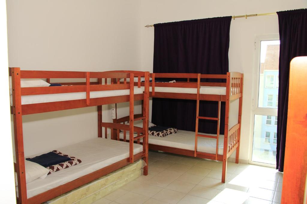 迪拜Dreams Hostel的带窗户的客房内的两张双层床