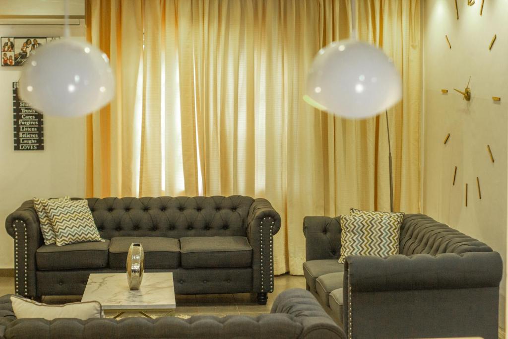 阿克拉3D's Luxury Properties的客厅设有两张沙发、一张桌子和气球