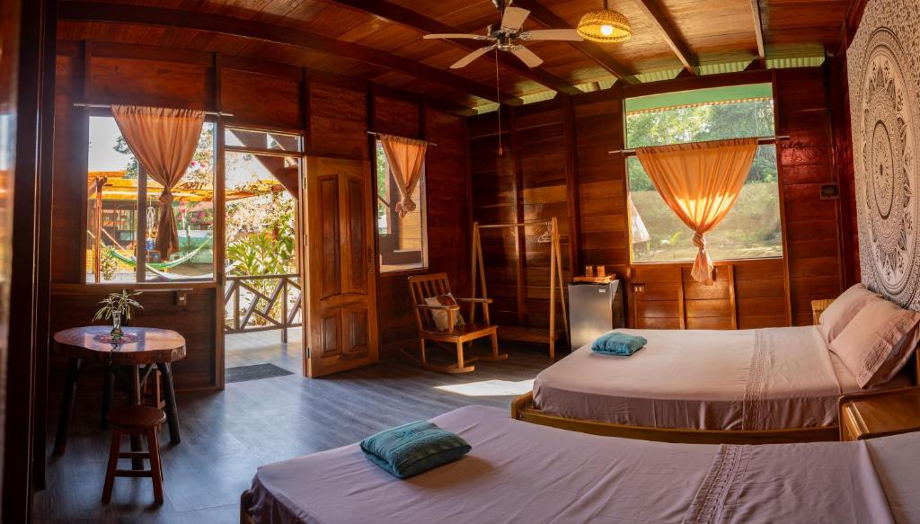 马尔多纳多港Aroldo Amazon Lodge的一间卧室设有两张床、一张桌子和窗户。