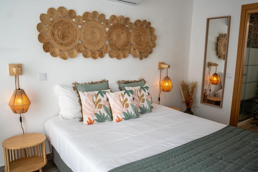 塔维拉Tavira Nomad Guesthouse的卧室配有带枕头的大型白色床