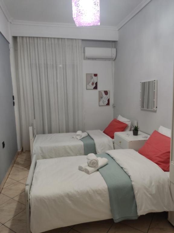 卡瓦拉Rafaela's Apartment的一间卧室配有三张床和毛巾